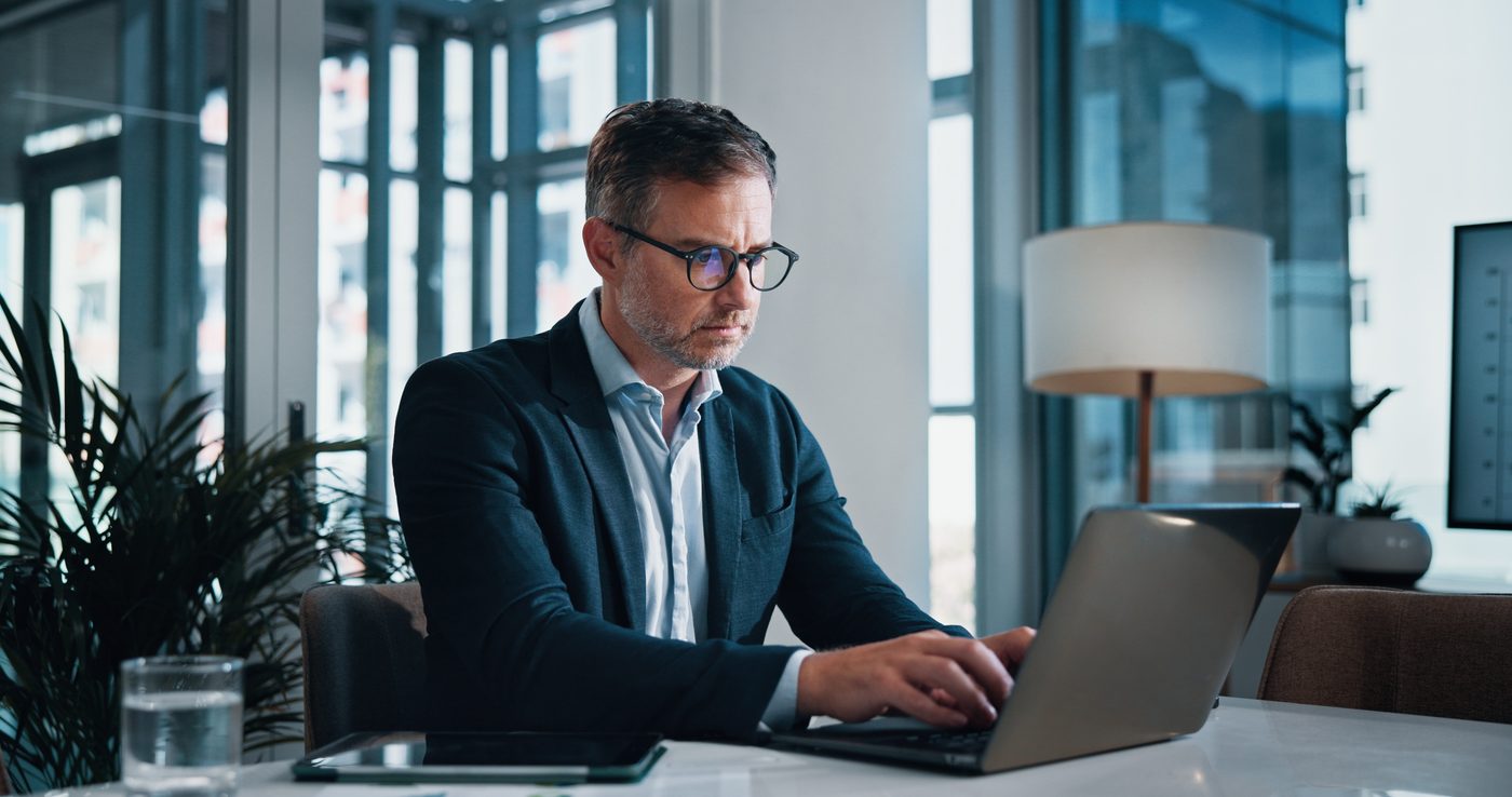 A professional working at a laptop in a modern office