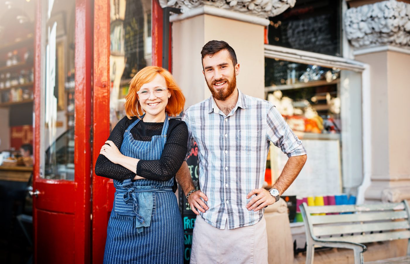 Owners of a small hospitality business standing outside their premises